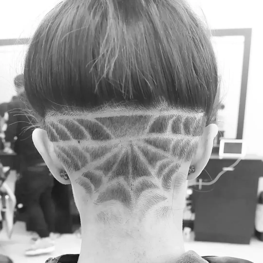 Custom spiderweb hair design carved into a fade